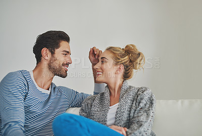 Buy stock photo Shot of a young couple enjoying a conversation on their sofa at home