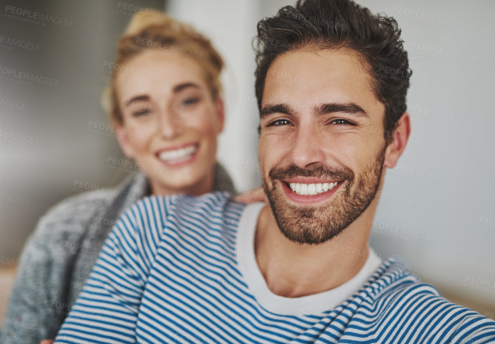 Buy stock photo Portrait of a happy young couple relaxing on their sofa at home