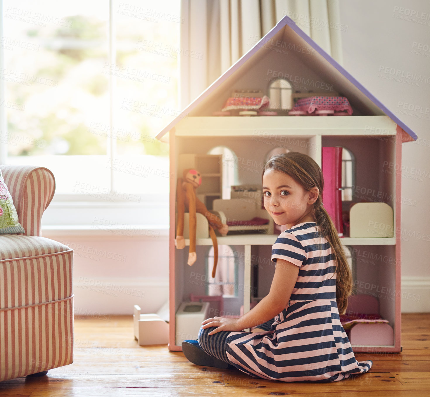 Buy stock photo Shot of a little girl playing with a dollhouse at home