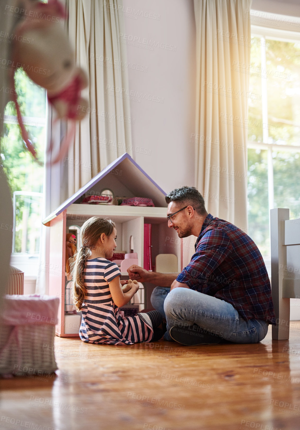 Buy stock photo Shot of a little girl playing with a dollhouse at home