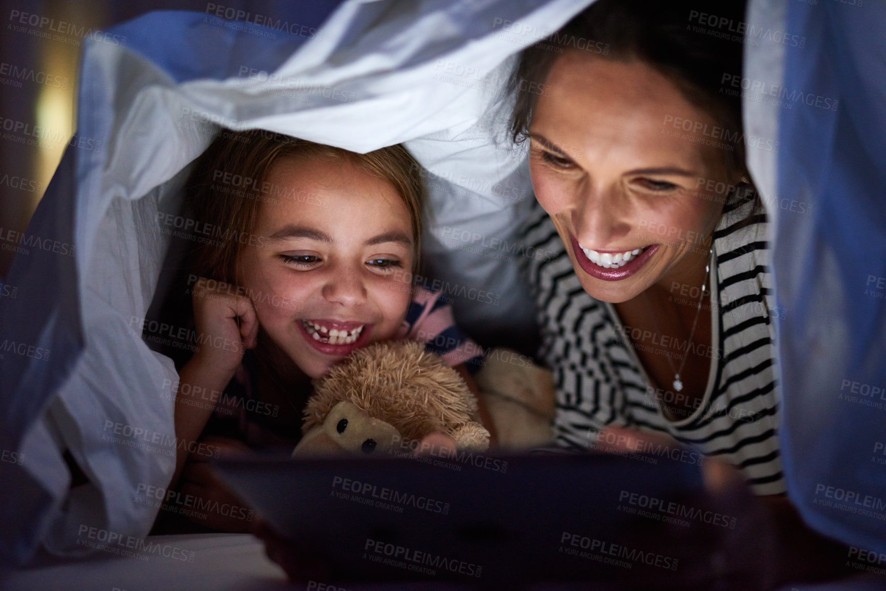 Buy stock photo Cropped shot of an attractive young woman reading her daughter a bedtime story