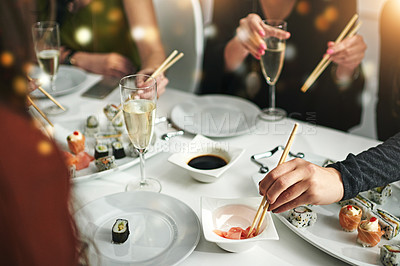 Buy stock photo Sushi, friends and eating food together for nutrition, diet and social get together in a restaurant. Meal, asian seafood and alcohol drink with hungry people eat and champagne while gathering 