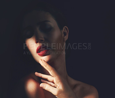 Buy stock photo Studio shot of a beautiful young woman posing against a black background