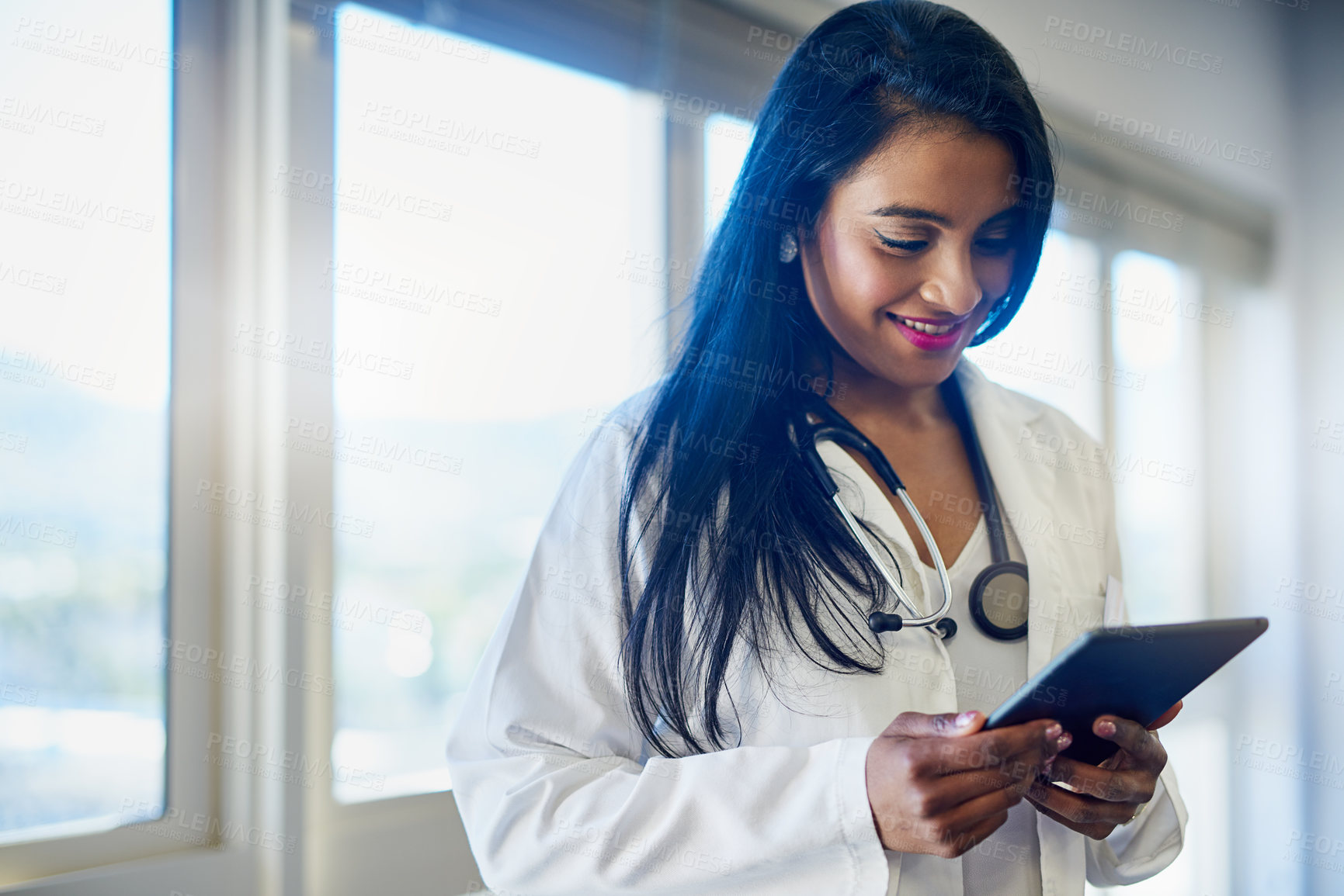 Buy stock photo Shot of a female doctor using a digital tablet in a hospital