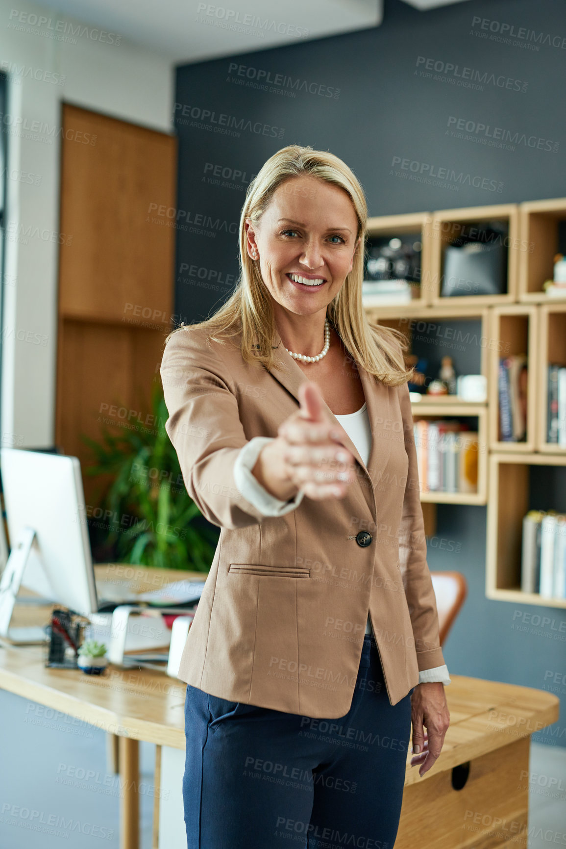 Buy stock photo Portrait of a mature businesswoman extending a handshake in an office
