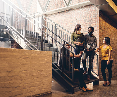 Buy stock photo Full length shot of a group of young designers gathered in a stairwell at the office