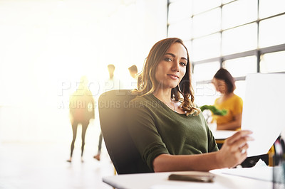 Buy stock photo Cropped portrait of an attractive young woman working in a modern office with her colleagues in the background