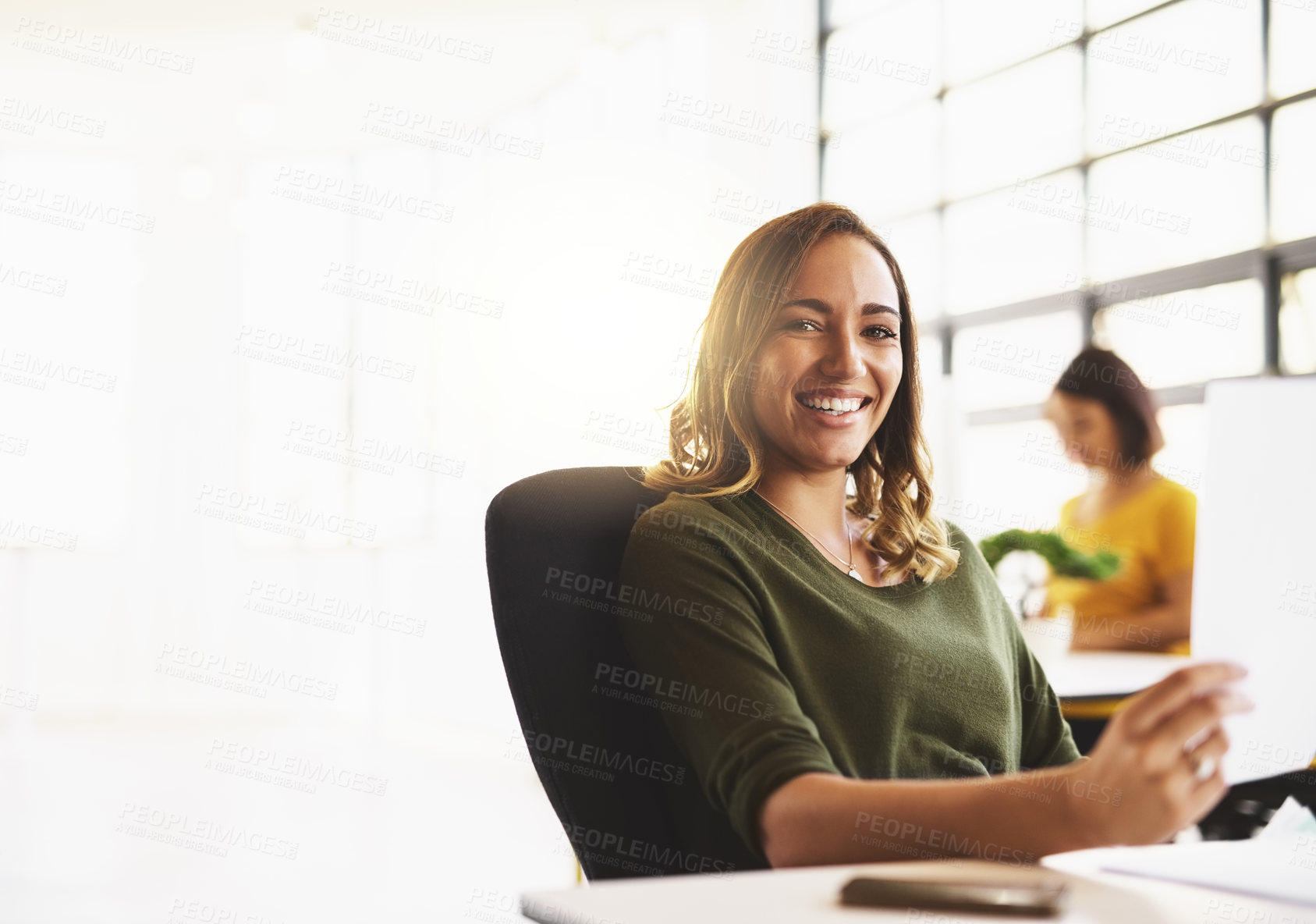 Buy stock photo Cropped portrait of an attractive young woman working in a modern office with her colleagues in the background