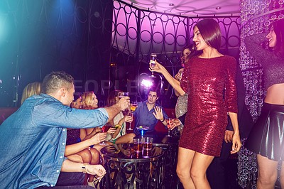 Buy stock photo Shot of a group of young adults enjoying themselves while out in a nightclub