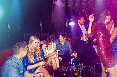 Buy stock photo Shot of a group of young adults enjoying themselves while out in a nightclub