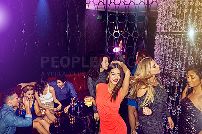 Buy stock photo Shot of a group of young adults enjoying themselves while out in a nightclub