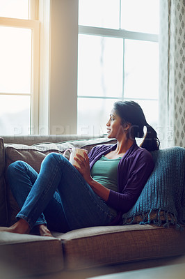 Buy stock photo Thinking, drinking coffee and Indian woman relax in living room for morning breakfast, latte or espresso at home. Tea, dream and girl on sofa for peace, calm and planning future in comfortable house