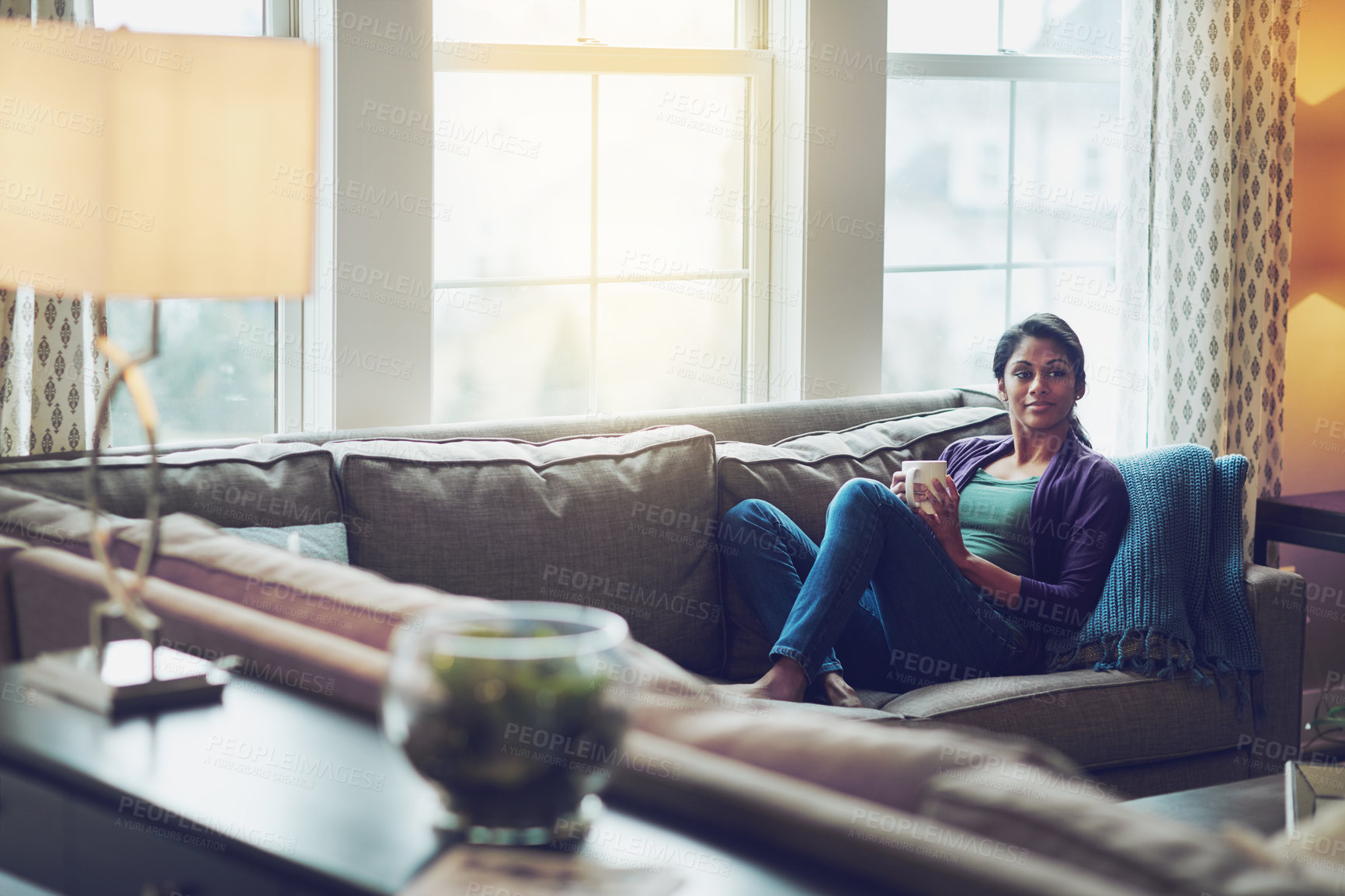 Buy stock photo Woman, coffee and relax on sofa by window with memory, thinking and start morning in living room. Indian person, tea cup or drink on couch with decision, perspective and reflection in lounge at house