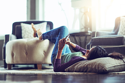 Buy stock photo Happy woman, relax and lying with phone on floor for communication, social media or news at home. Female person on mobile smartphone for online browsing, chatting or texting in living room at house