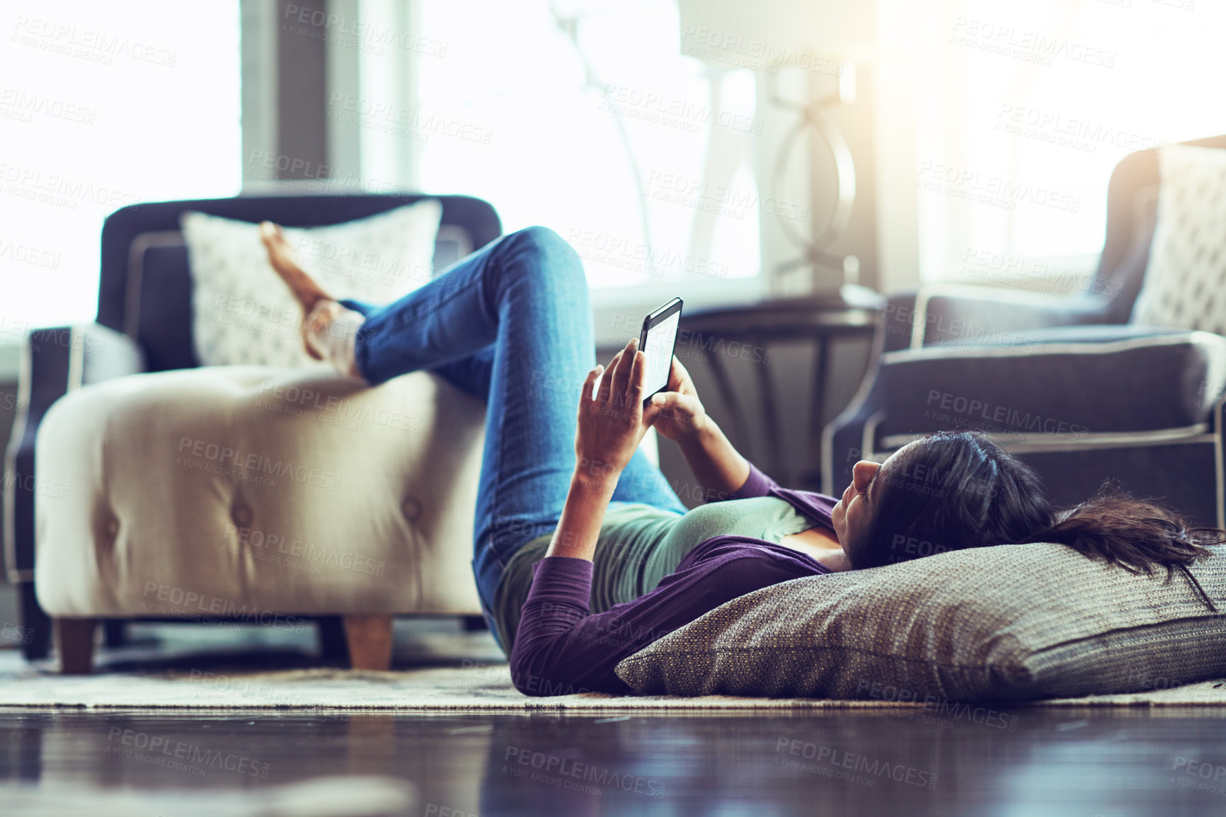 Buy stock photo Woman, phone and texting on floor in home, reading and scroll on mobile app in living room. Girl, smartphone and lying with pillow for notification, contact and relax on carpet with social network