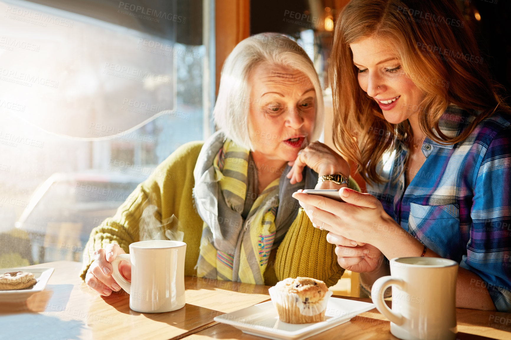 Buy stock photo Smile, senior woman and daughter browsing smartphone in cafe for memories with social media with relax. Funny, post and tech savvy in restaurant with coffee, muffin and sunshine in retirement.