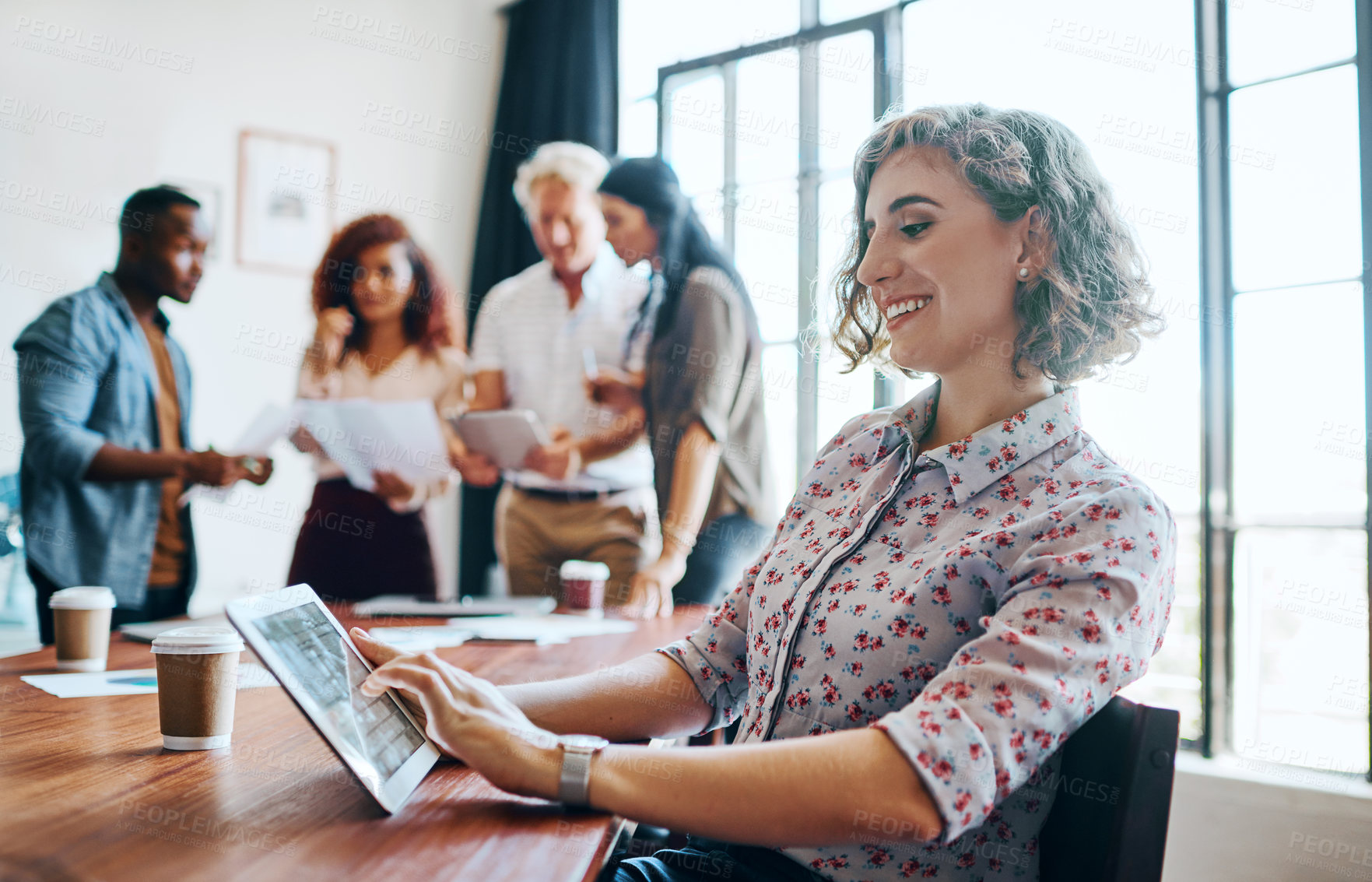 Buy stock photo Shot of a cheerful businesswoman working on her laptop while being seated in the office