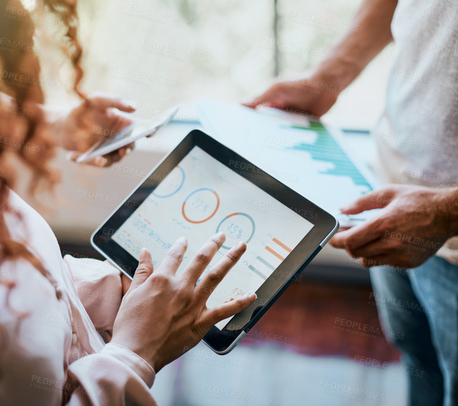 Buy stock photo Shot of two unrecognizable people's hands working on a tablet and looking at the business's charts in the office