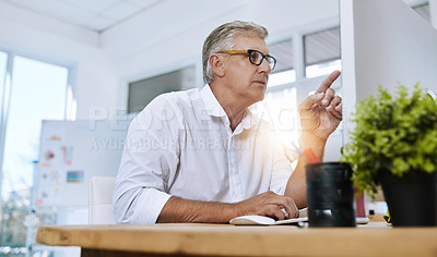Buy stock photo Shot of a mature businessman with glasses working on his computer while sitting in the office at work