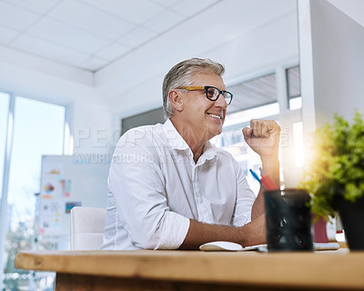 Buy stock photo Shot of a mature businessman with glasses working on his computer while sitting in the office at work