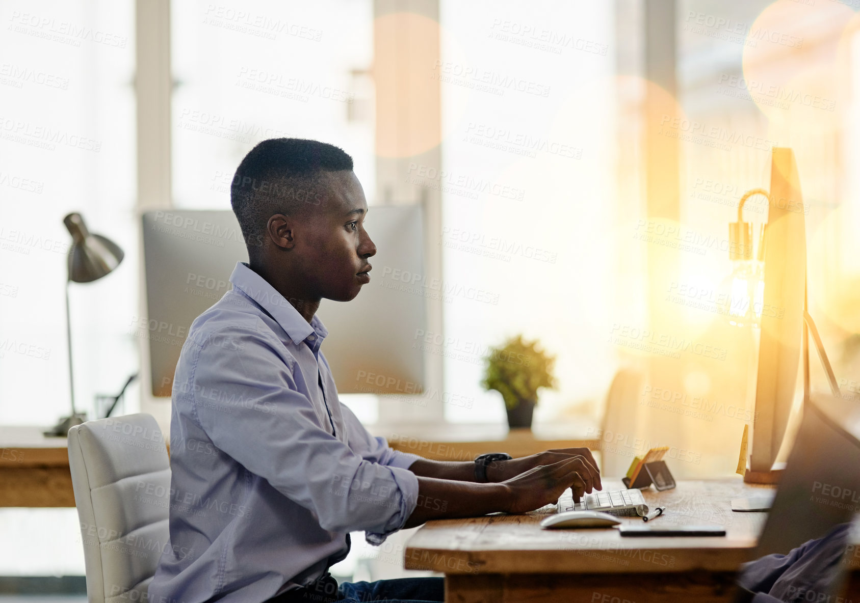 Buy stock photo Serious, black man and computer for typing as journalist, writer and editor in publication or agency. African male person, technology and working on article, blog and newsletter for online readership