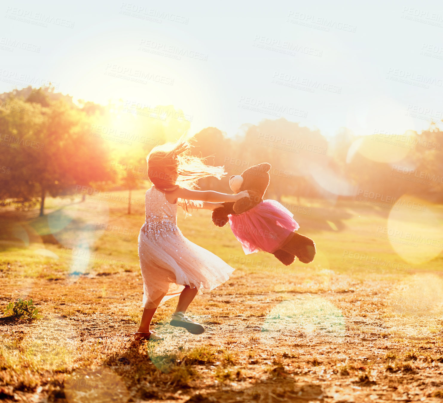 Buy stock photo Playing, child or girl with teddy bear in park for love, orphan or toy for support, care or therapy healing. Spinning, nature or kid with stuffed animal, princess costume and donation gift for games