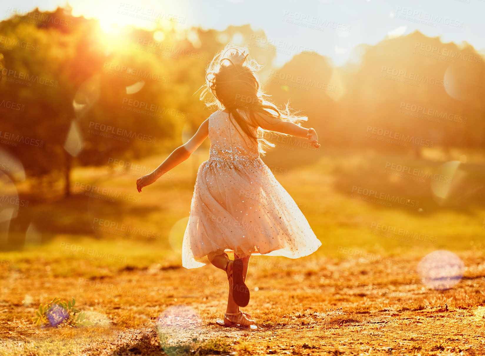 Buy stock photo Girl, child princess and running in nature for freedom, royal adventure and field for playing games. Female person, energy and back of kid on countryside vacation, lens flare and outdoor game in park