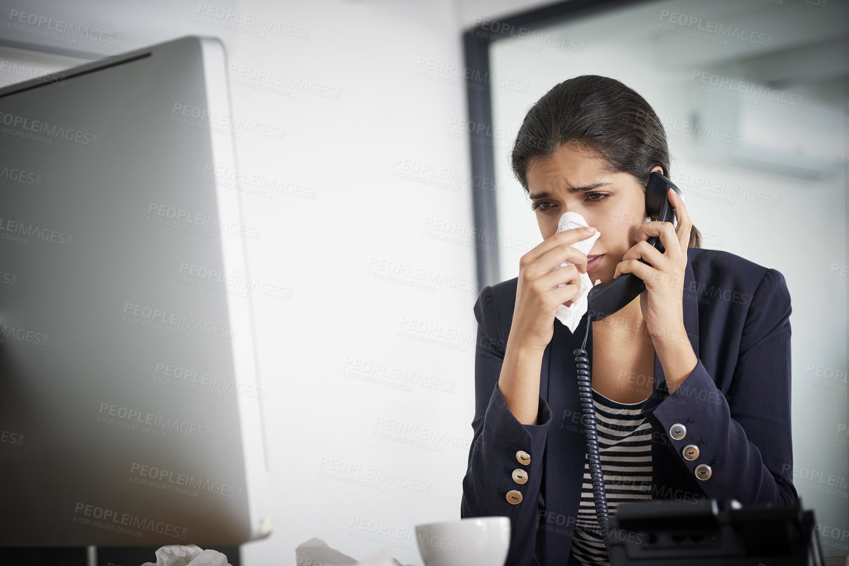 Buy stock photo Shot of a young businesswoman making a call while blowing her nose and working in the office