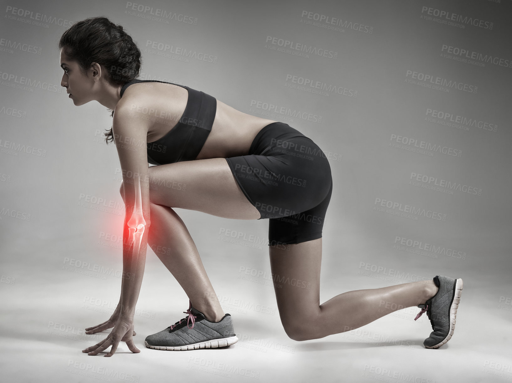 Buy stock photo Studio shot of an attractive young woman getting ready to sprint while CGI shows her injured elbow