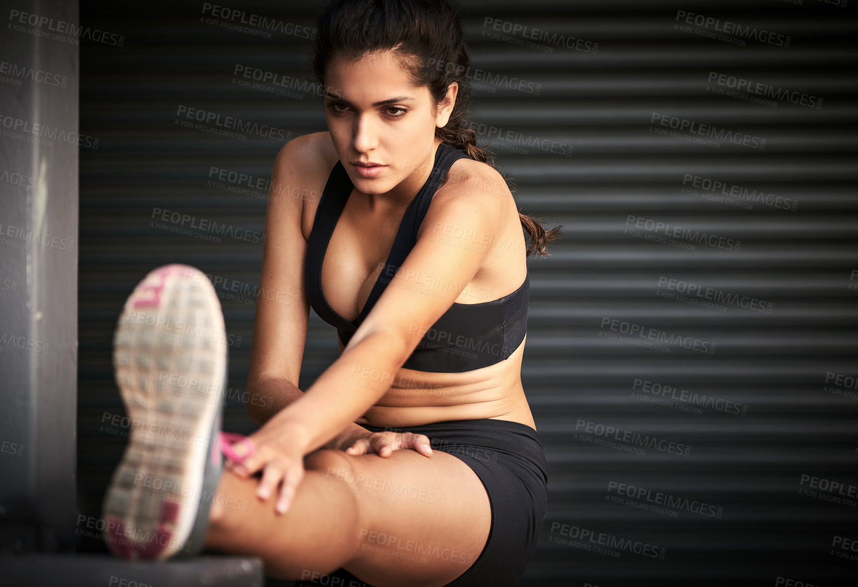 Buy stock photo Woman, exercise and stretching legs in gym warehouse for fitness, sports and physical activity. Female person, workout and muscle warm up for training, health and running performance as athlete