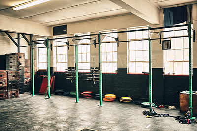 Buy stock photo Shot of the interior of a health club full of gym equipment ready for use