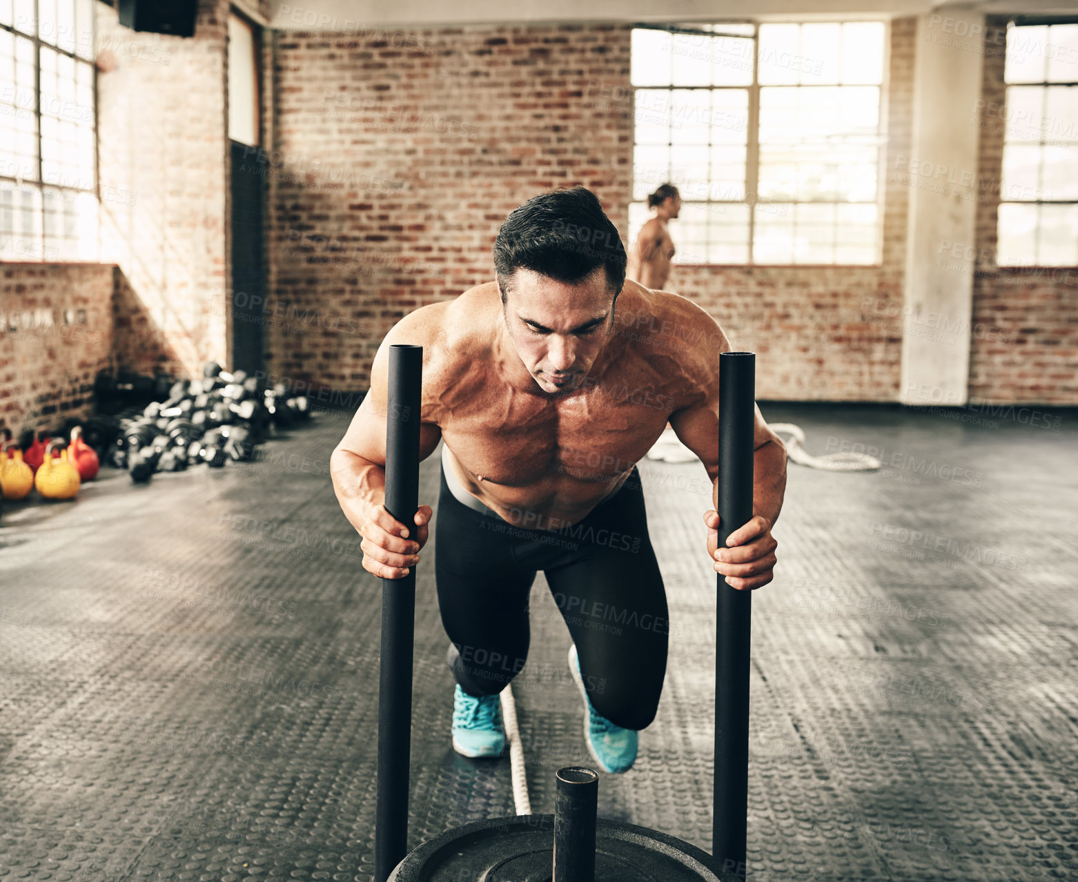 Buy stock photo Shot of a fit and determined young man making use of weights to workout in a gym