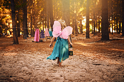 Buy stock photo Shot of an unrecognizable little girl holding a lamp while running around outside in the woods