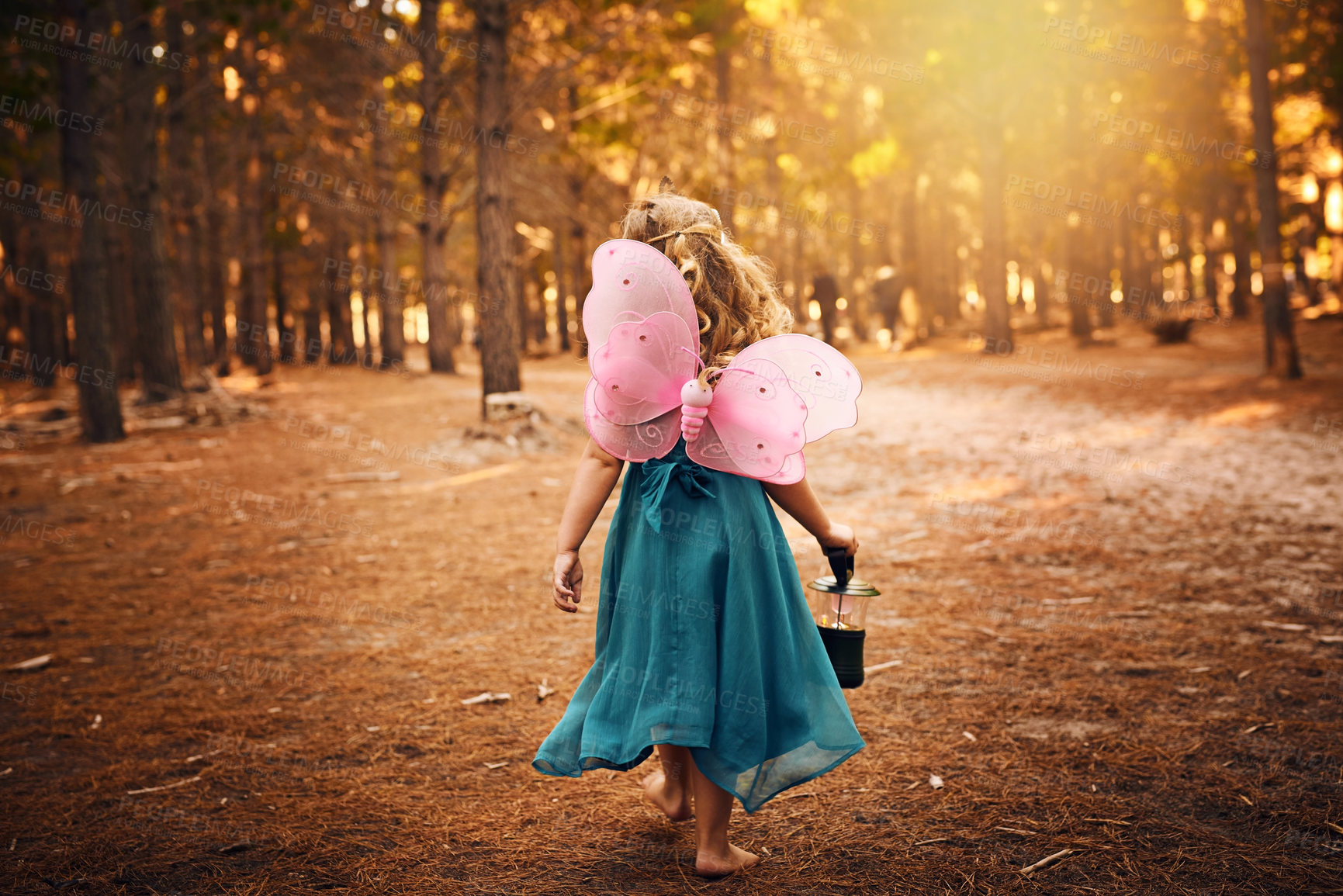 Buy stock photo Shot of an unrecognizable little girl holding a lamp while running around outside in the woods