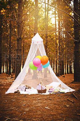 Buy stock photo Shot of a tent made for a children's birthday party filled with balloons and presents outside in the woods