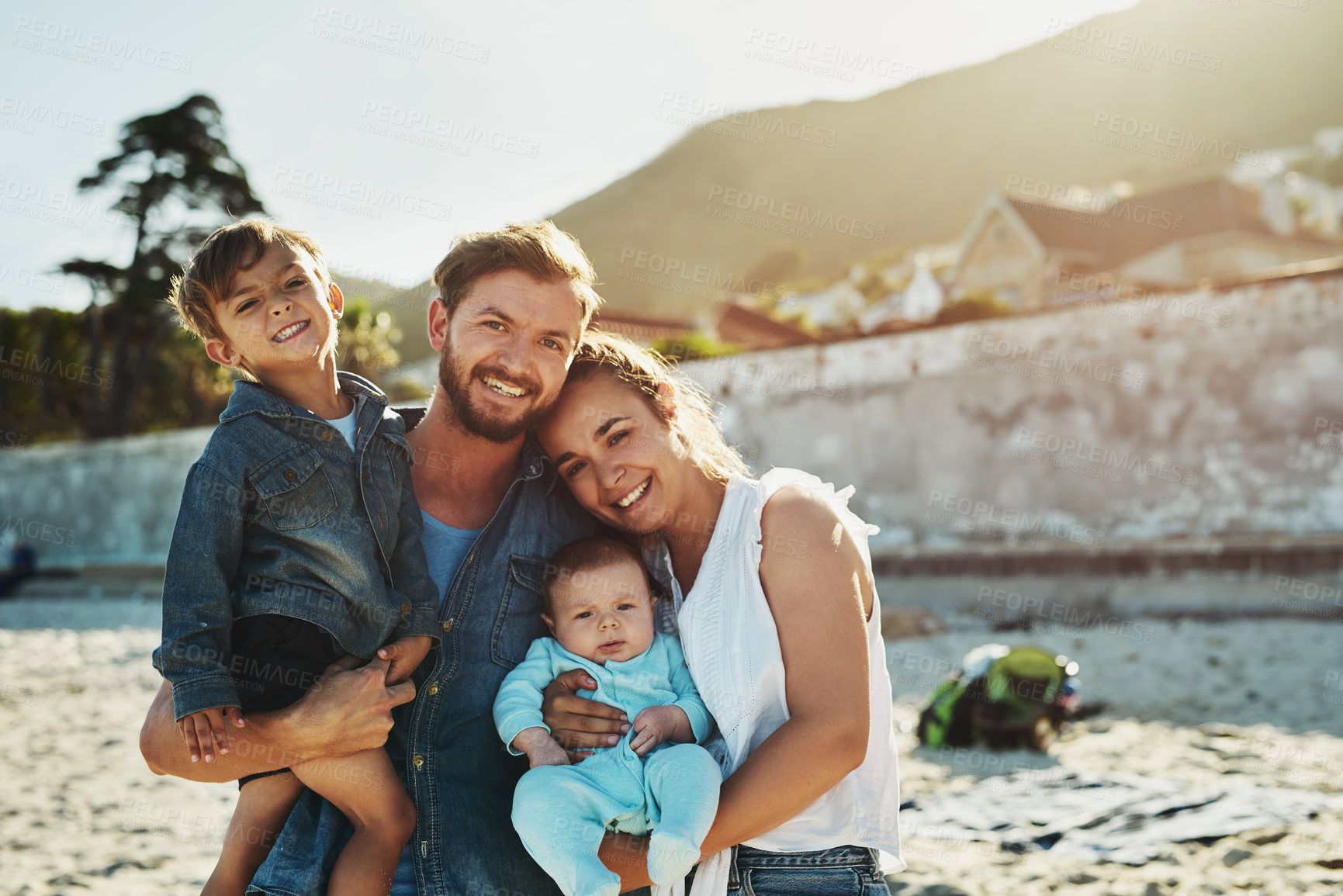 Buy stock photo Shot of a young family spending quality time at the beach