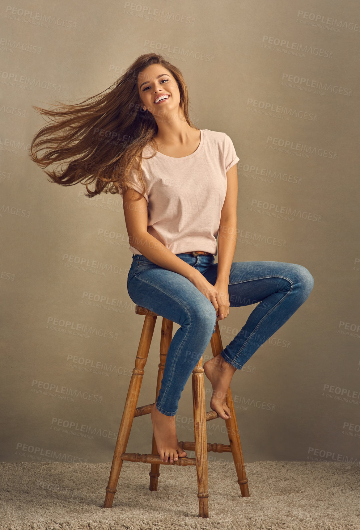 Buy stock photo Chair, fashion and studio portrait of woman for hair care and confidence for style or cosmetics. Beauty, model girl and happy for shampoo, denim or jeans and shine or trendy outfit by brown backdrop