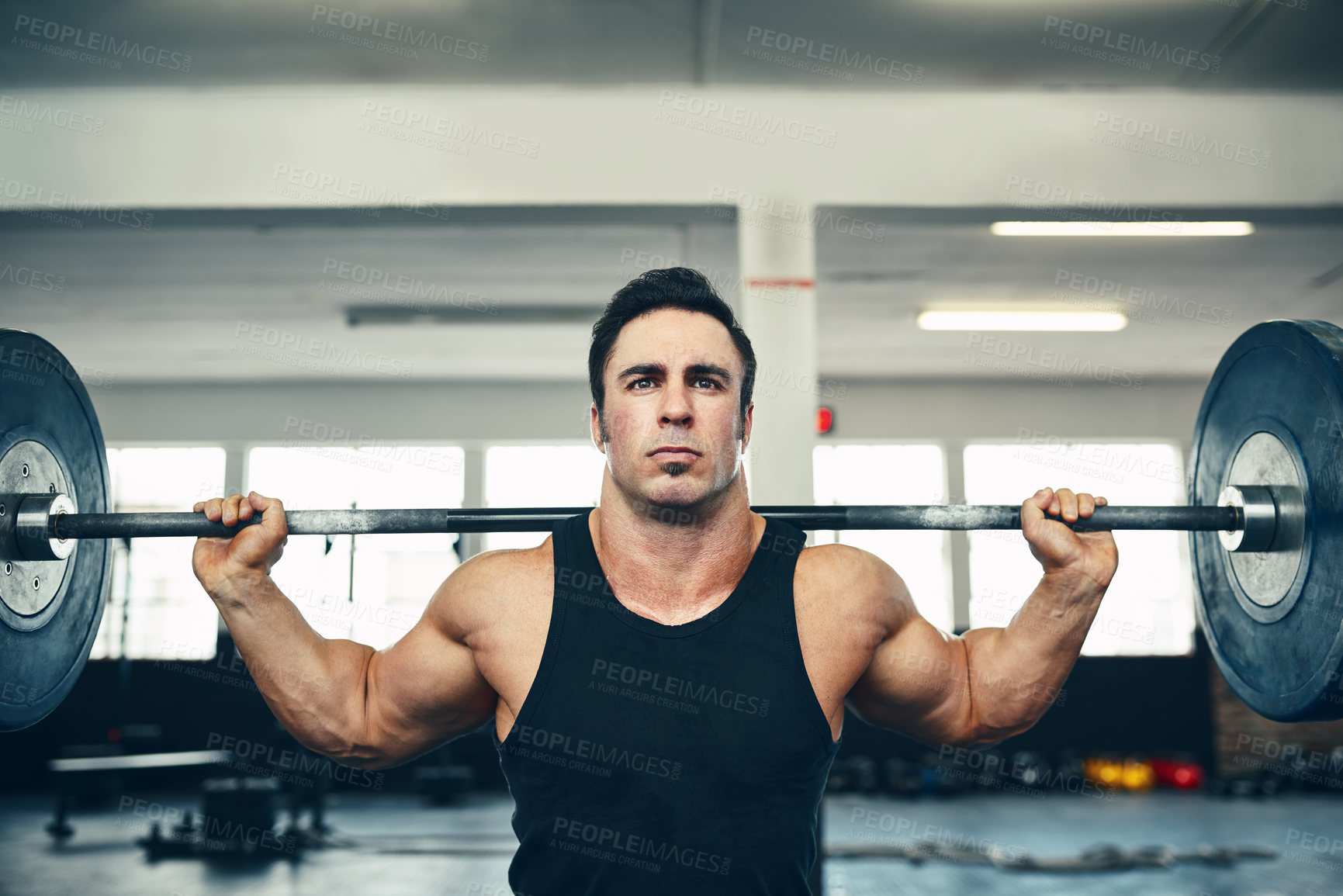 Buy stock photo Shot of a man lifting weights at the gym