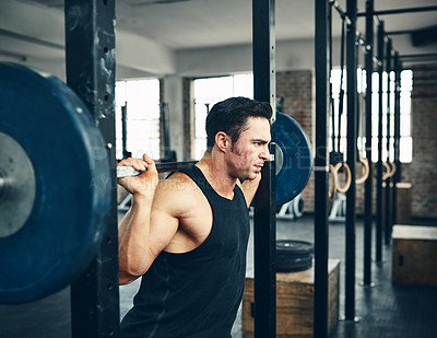 Buy stock photo Shot of a man lifting weights at the gym