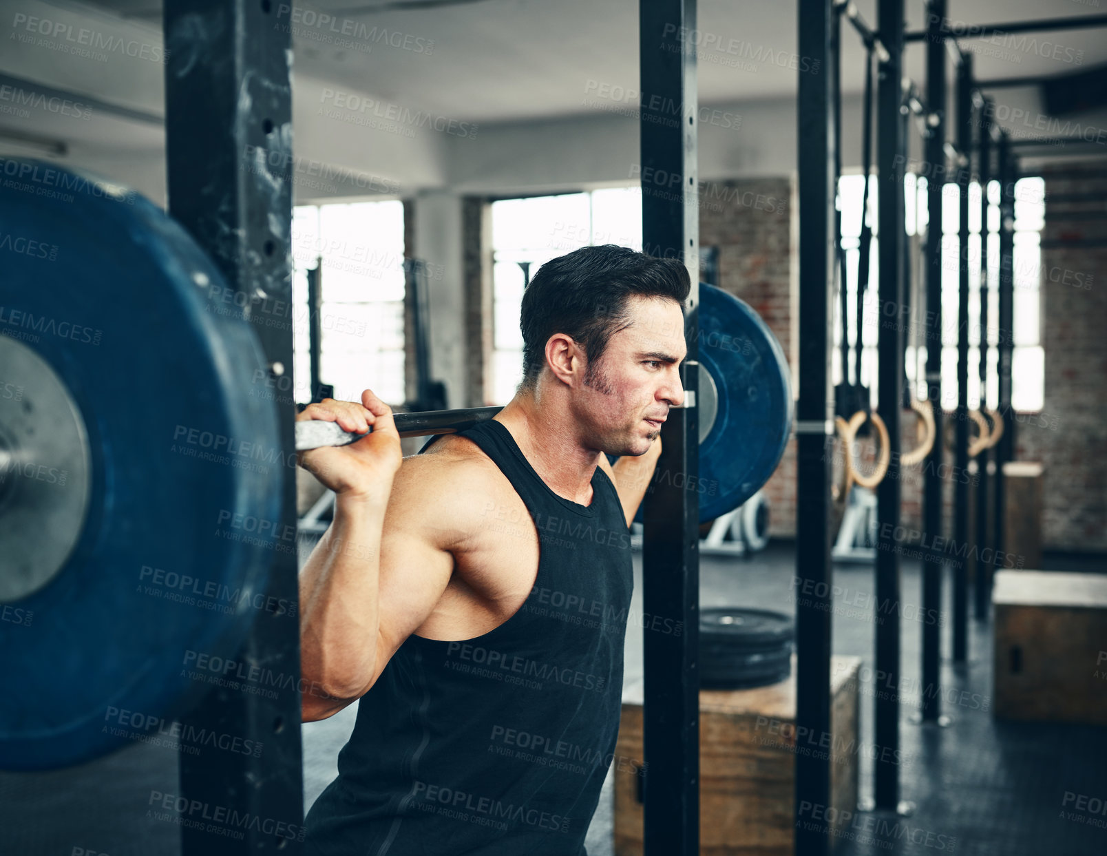 Buy stock photo Shot of a man lifting weights at the gym