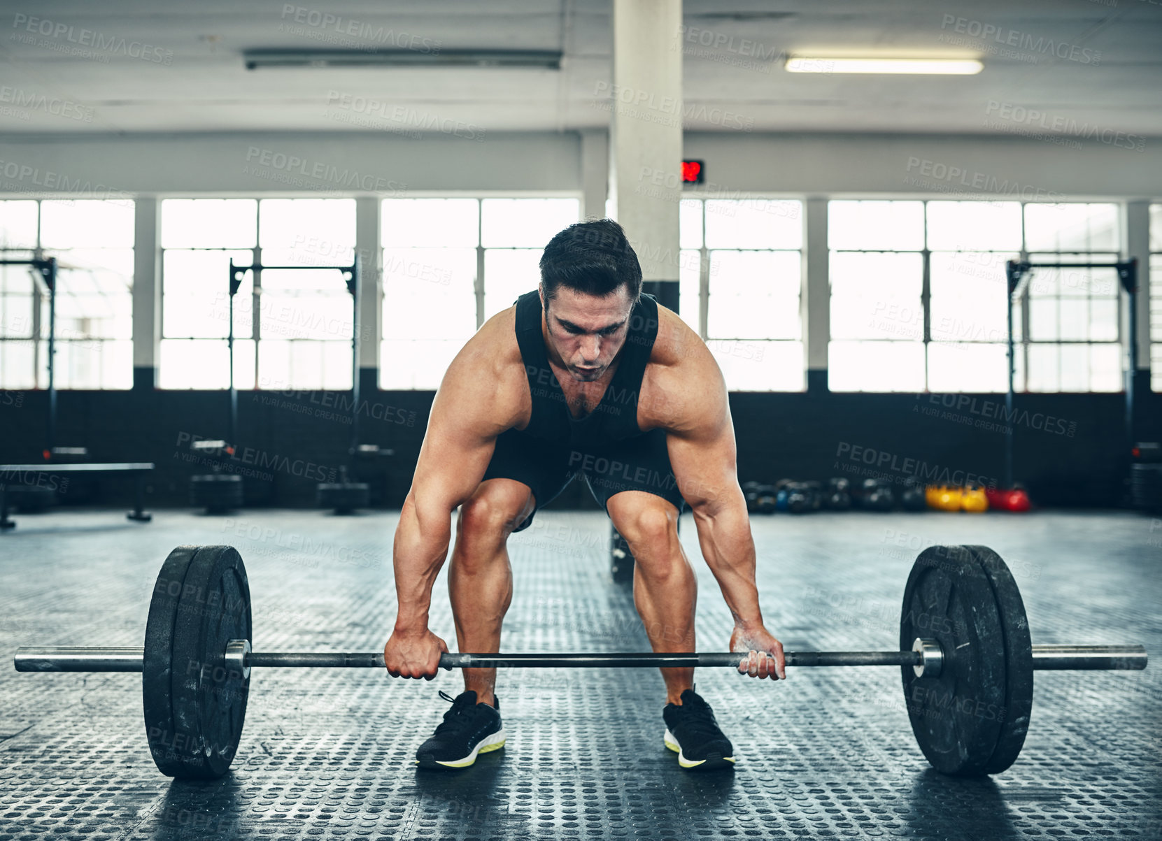 Buy stock photo Shot of a man lifting weights at the gym