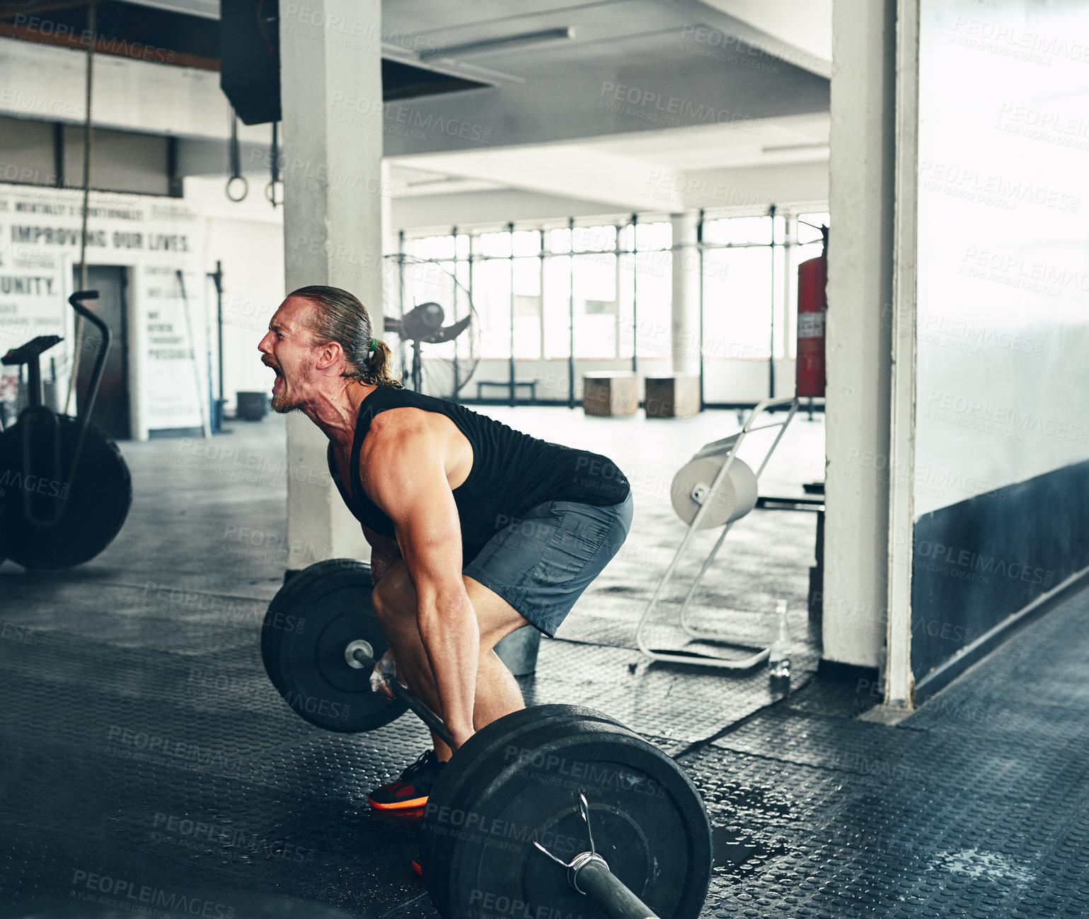 Buy stock photo Shot of a man lifting weights at the gym