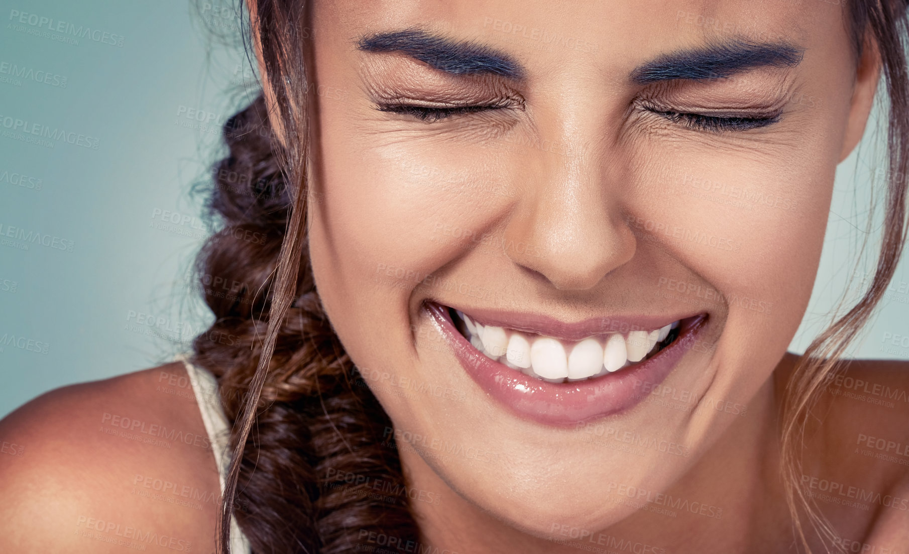 Buy stock photo Funny, closeup and girl with smile or skincare on blue background for beauty, wellness or makeup glow. Face, eyes closed and happy woman in studio for dermatology, smooth results or facial health