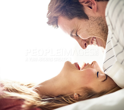 Buy stock photo Shot of an affectionate young couple gazing into each others eyes in the bedroom