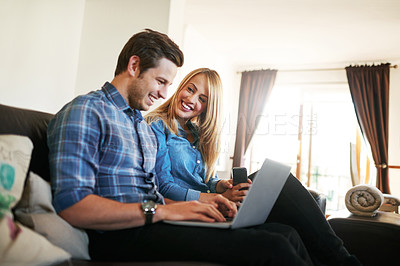 Buy stock photo Cropped shot of an affectionate young couple surfing the net while sitting on their sofa at home