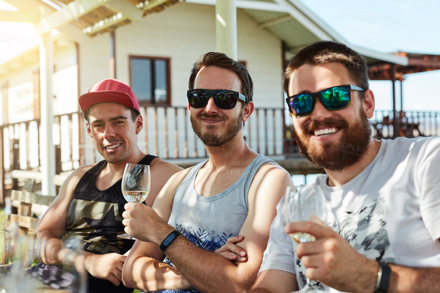 Buy stock photo Friends, portrait and wine drink outdoor for celebration, party and holiday together by guesthouse. Happy men, group and cheers for alcohol, festival or event on vacation or weekend in countryside