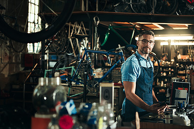 Buy stock photo Man, portrait and bicycle mechanic with tools in small business for fix, repair or maintenance. Young male person, cycle engineer or bike technician with equipment for job or career at workshop