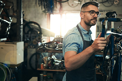 Buy stock photo Man, bicycle technician and fix with inspection for maintenance or small business at repair shop. Young male person, cycling mechanic or engineer working on bike with tools or equipment at workshop