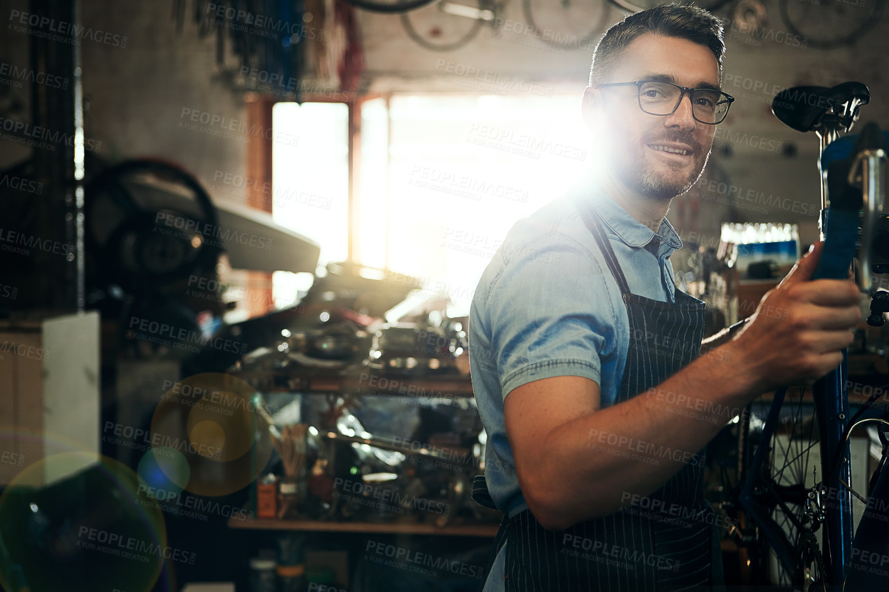 Buy stock photo Happy man, portrait and bicycle mechanic with inspection for fix or maintenance at repair shop. Young male person, cycling technician or engineer working on bike with tools or equipment at workshop