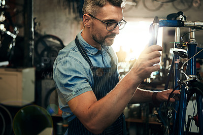 Buy stock photo Man, bicycle mechanic and fix with inspection for maintenance or small business at repair shop. Young male person, cycling technician or engineer working on bike with tools or equipment at workshop
